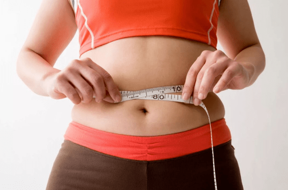 Girl measuring waist rolls